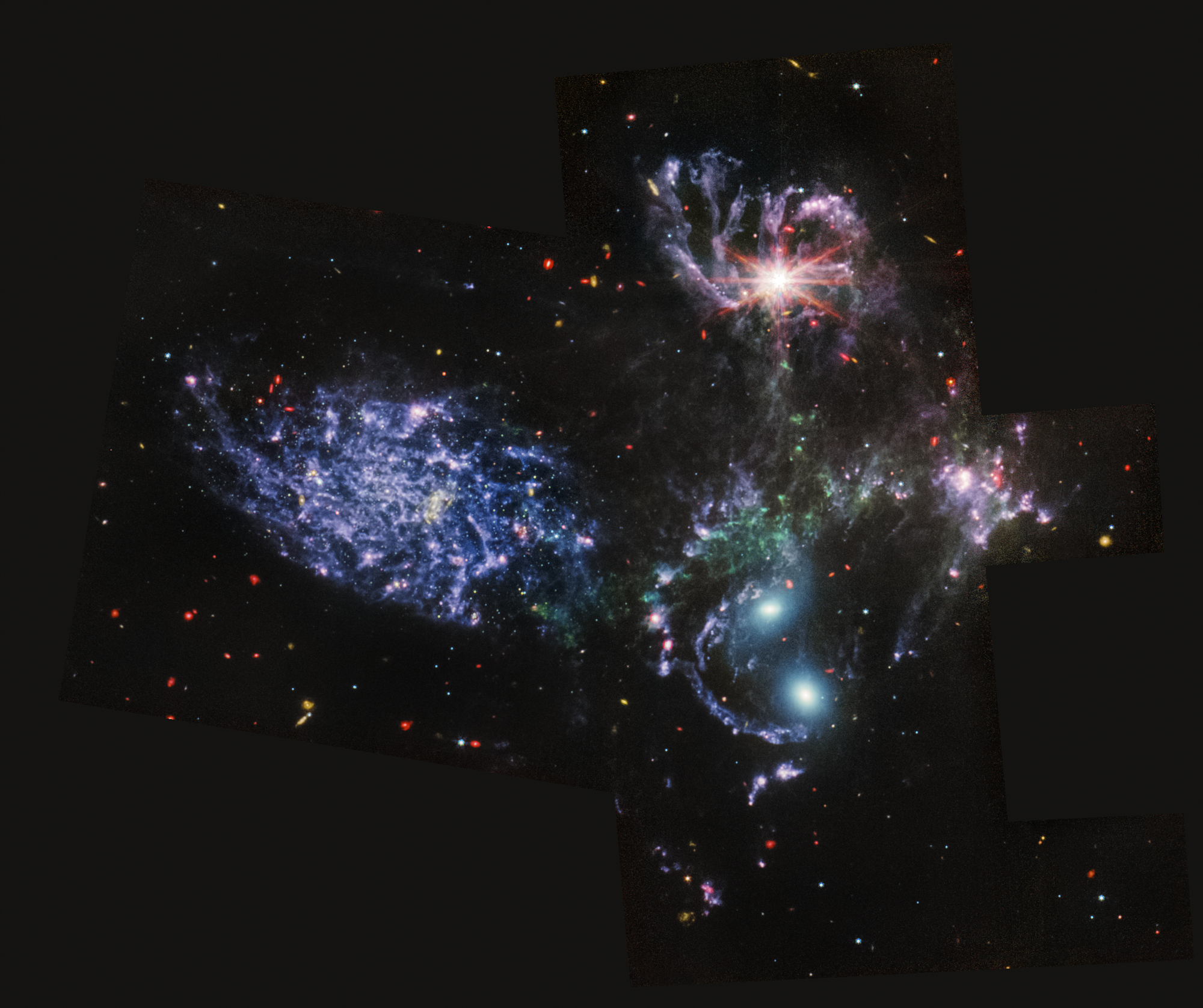 MIRI image of Stephan's Quintet, a grouping of five 
                        galaxies located in the constellation Pegasus. In this image, the red represents dusty, 
                        star-forming regions, as well as extremely distant, early galaxies and galaxies enshrouded in 
                        thick dust. Blue point sources show stars or star clusters without dust. 
                        Diffuse areas of blue indicate dust that has a significant amount of large 
                        hydrocarbon molecules. For small background galaxies scattered throughout the image,
                         the green and yellow colors represent more distant, earlier galaxies that are rich 
                         in these hydrocarbons as well.